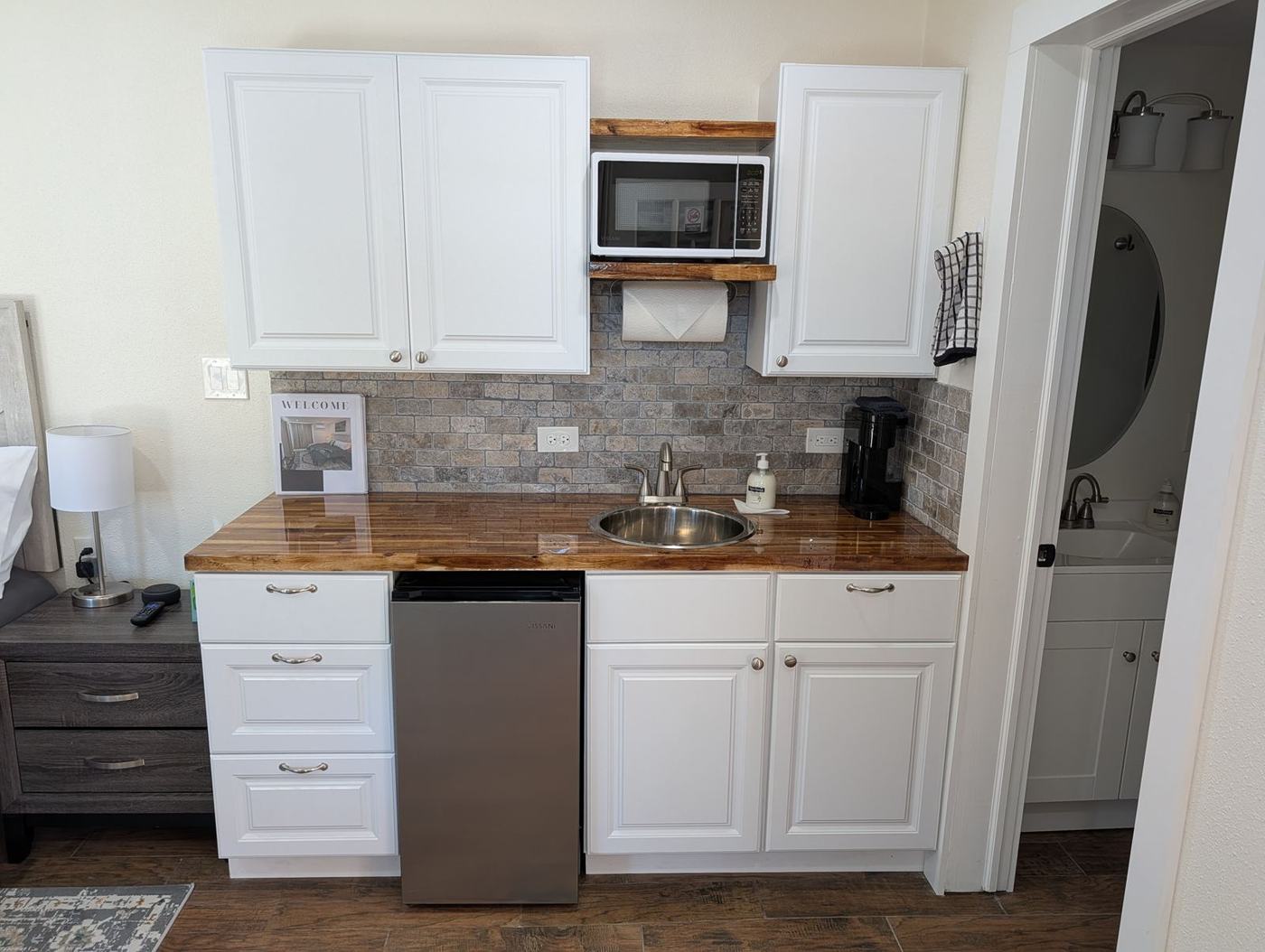 Kitchenette with butcher-block counter, sink, microwave and small refrigerator
